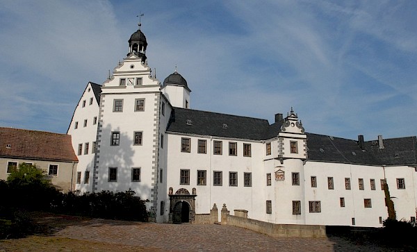 Schloss mit Blick auf den Haupteingang: großes weißes Gebäude mit Schieferdach